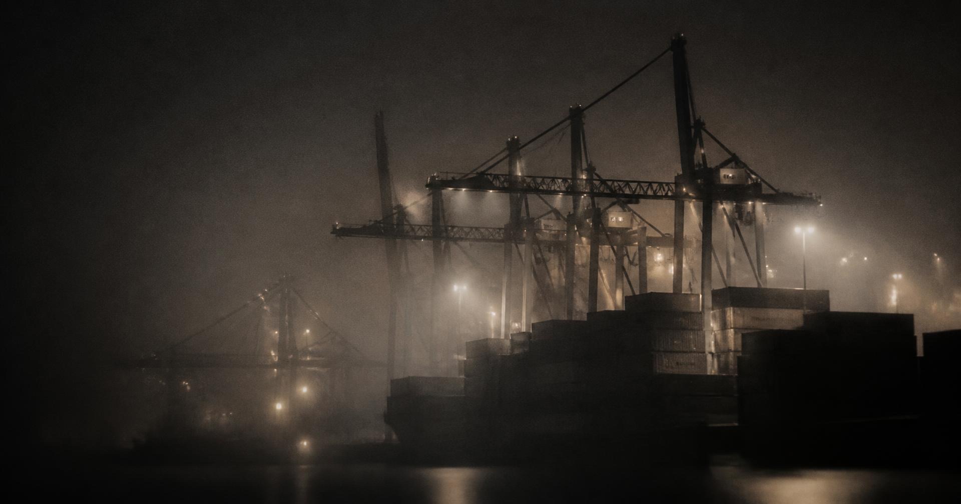 Cranes and containers at a port at night